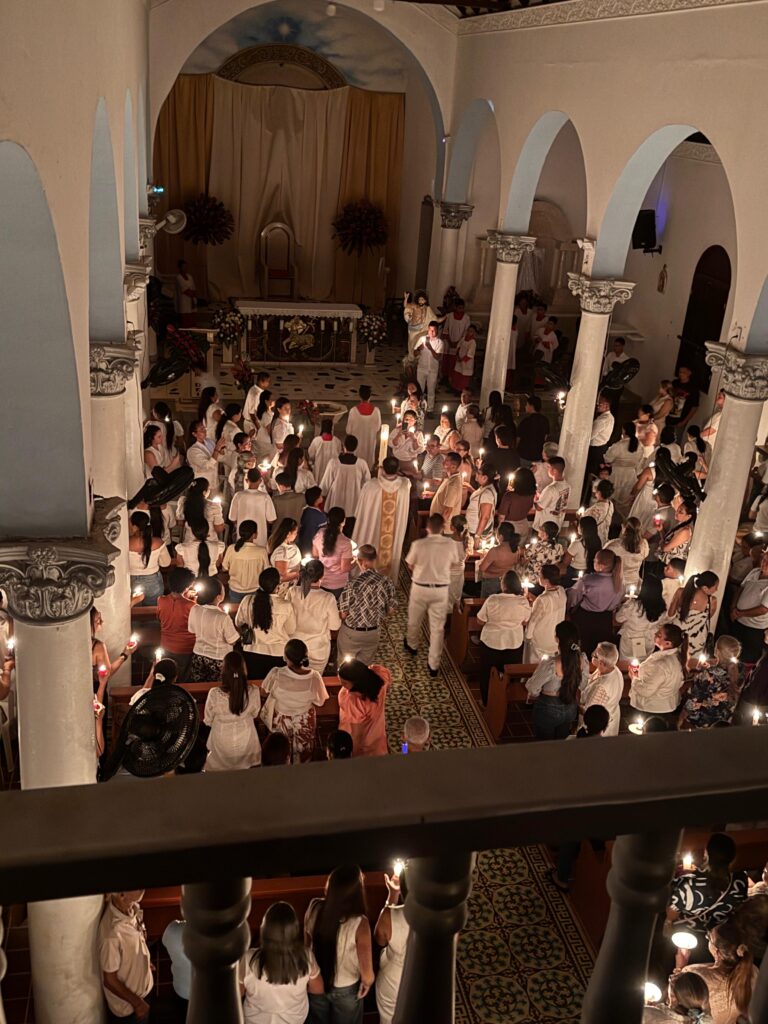 La luz de las velas acompaña la fe y la unión de los fieles en una noche de reflexión y oración.